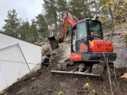 Rød liten gravemaskin